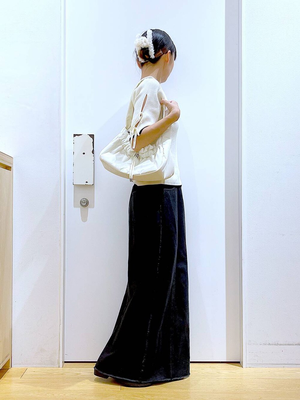 ホワイト系のハンドバッグ、ブラック系のローファー、ホワイト系のニット/セーターを着用したレディースの秋コーディネートの4枚目の写真