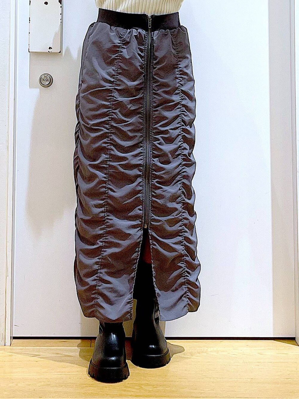 ホワイト系のニット/セーター、ホワイト系のショルダーバッグ、ブラック系のブーツを着用したレディースの秋コーディネートの8枚目の写真