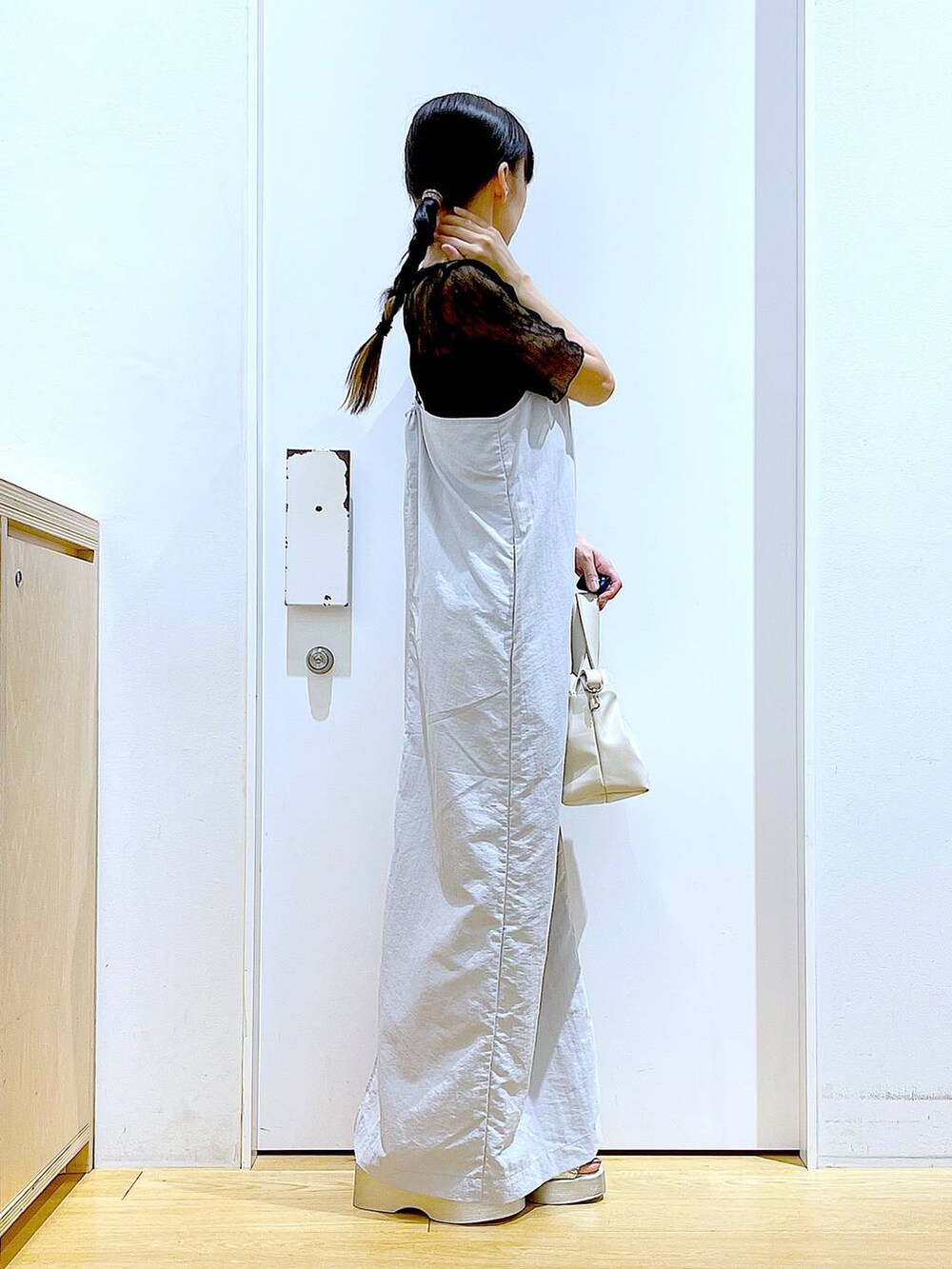 グレー系のワンピース、ホワイト系のショルダーバッグ、シルバー系のサンダルを着用したレディースの夏コーディネートの4枚目の写真