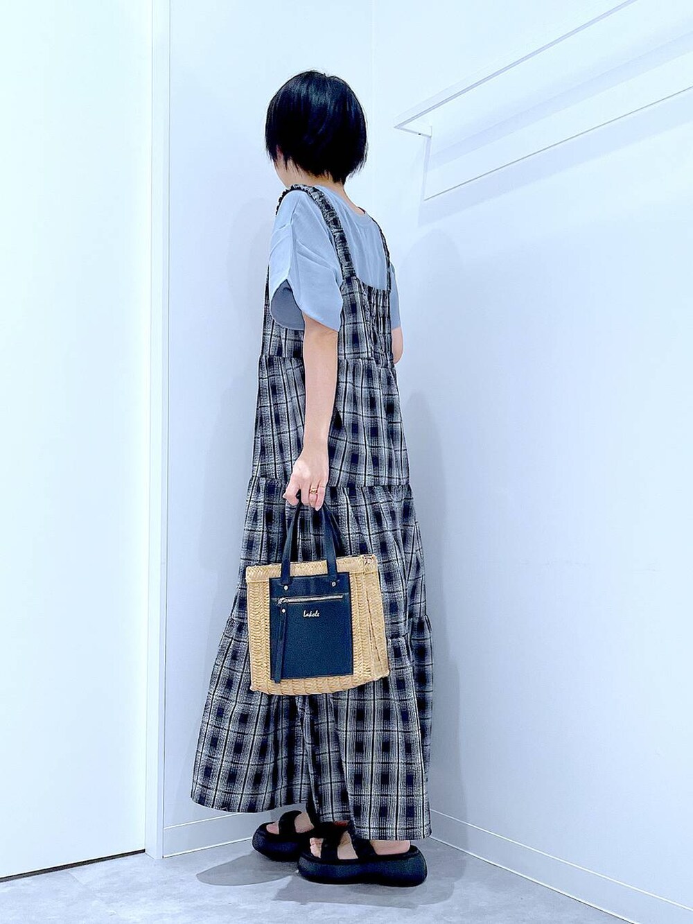 ベージュ系のショルダーバッグ、ブラック系のサンダル、ブラック系のワンピースを着用したレディースの夏コーディネートの3枚目の写真