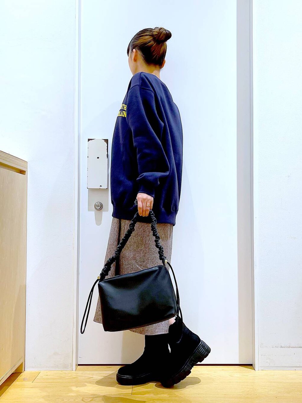 ブラック系のショルダーバッグ、ブラック系のブーツ、ブラウン系のワンピースを着用したレディースの冬コーディネートの3枚目の写真