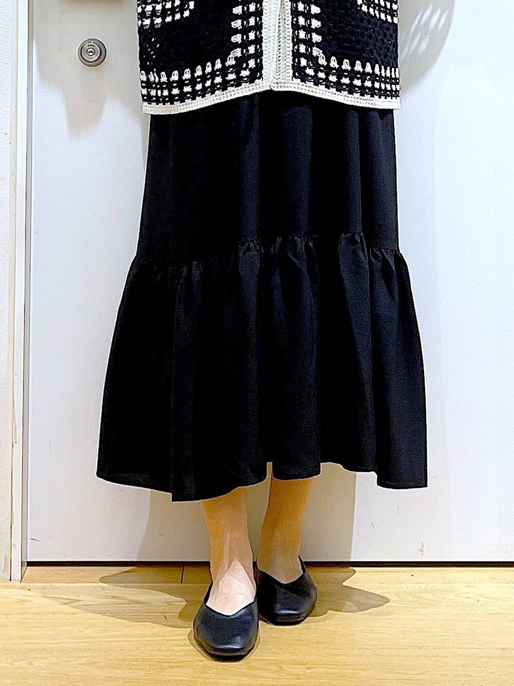 シルバー系のショルダーバッグ、ブラック系のパンプス、ブラック系のワンピースを着用したレディースの春コーディネートの8枚目の写真