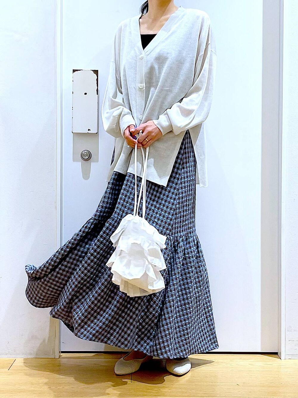 ホワイト系のショルダーバッグ、ブルー系のワンピース、ホワイト系のパンプスを着用したレディースの春コーディネートの6枚目の写真