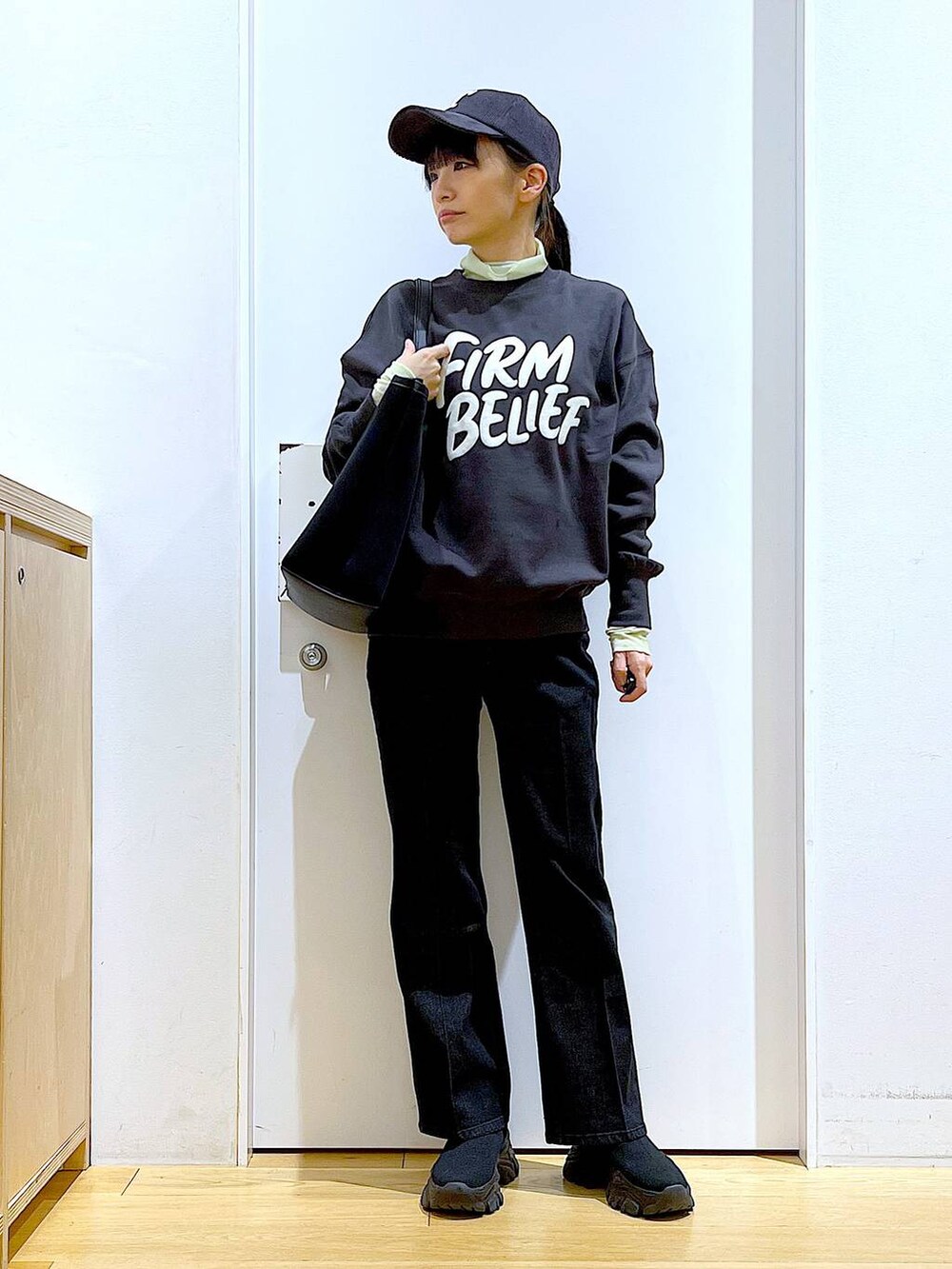 グレー系のデニムパンツ、グレー系のスウェット、グリーン系のその他トップスを着用したレディースの冬コーディネートの2枚目の写真