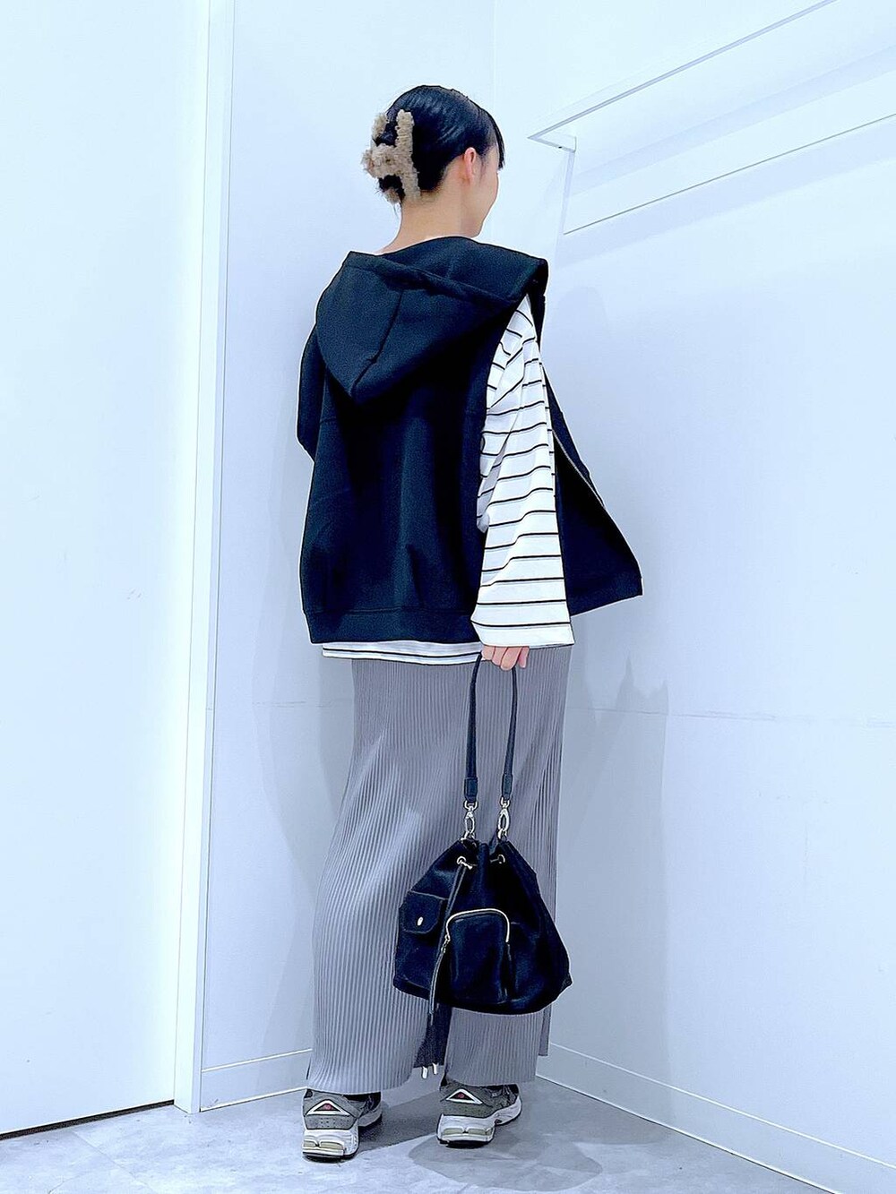 ブラック系のショルダーバッグ、ホワイト系のTシャツ/カットソー、グレー系のスカートを着用したレディースの春コーディネートの5枚目の写真