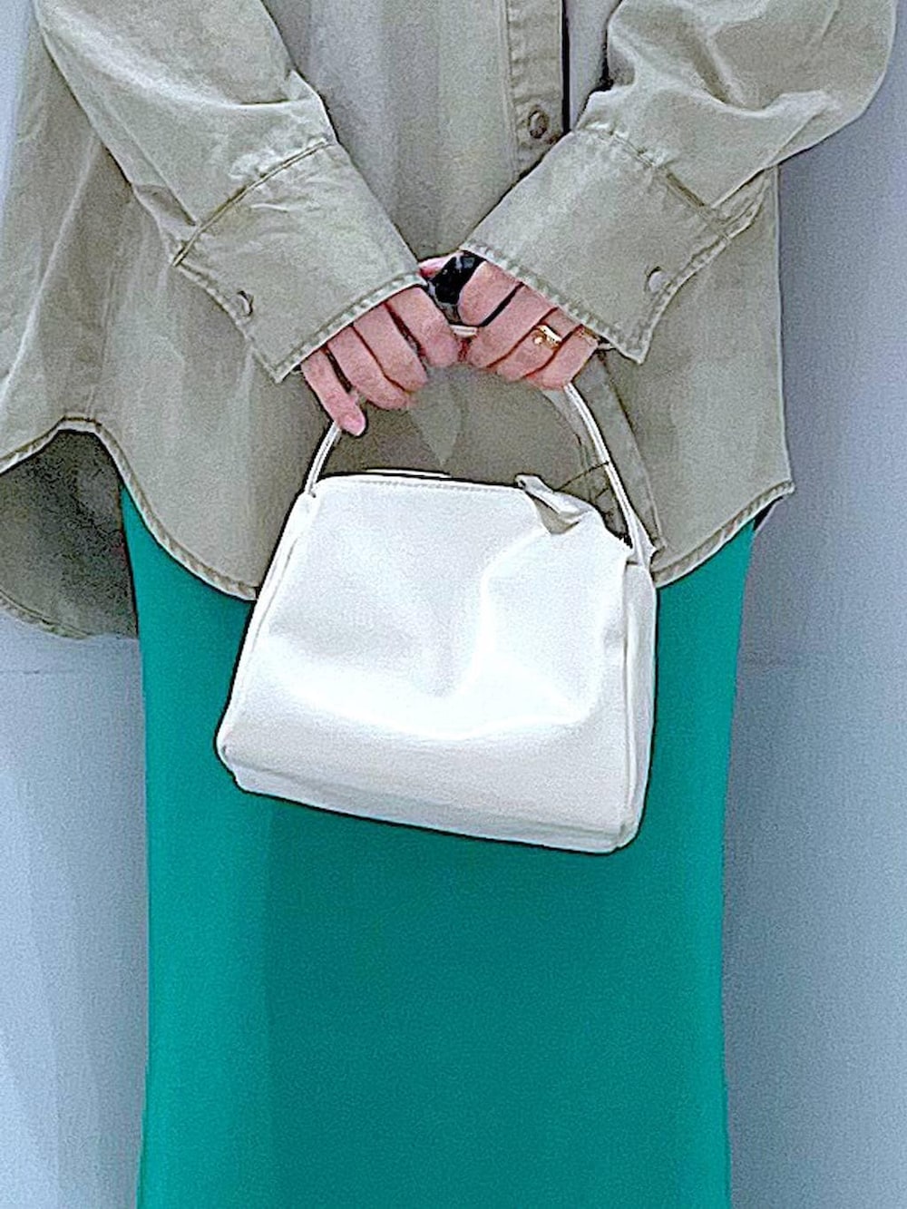 ホワイト系のショルダーバッグ、ベージュ系のシャツ/ブラウス、グリーン系のスカートを着用したレディースの春コーディネートの9枚目の写真