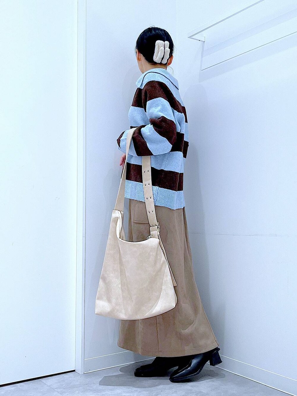 ブラック系のブーツ、ブラウン系のスカート、ブルー系のニット/セーターを着用したレディースの冬コーディネートの3枚目の写真