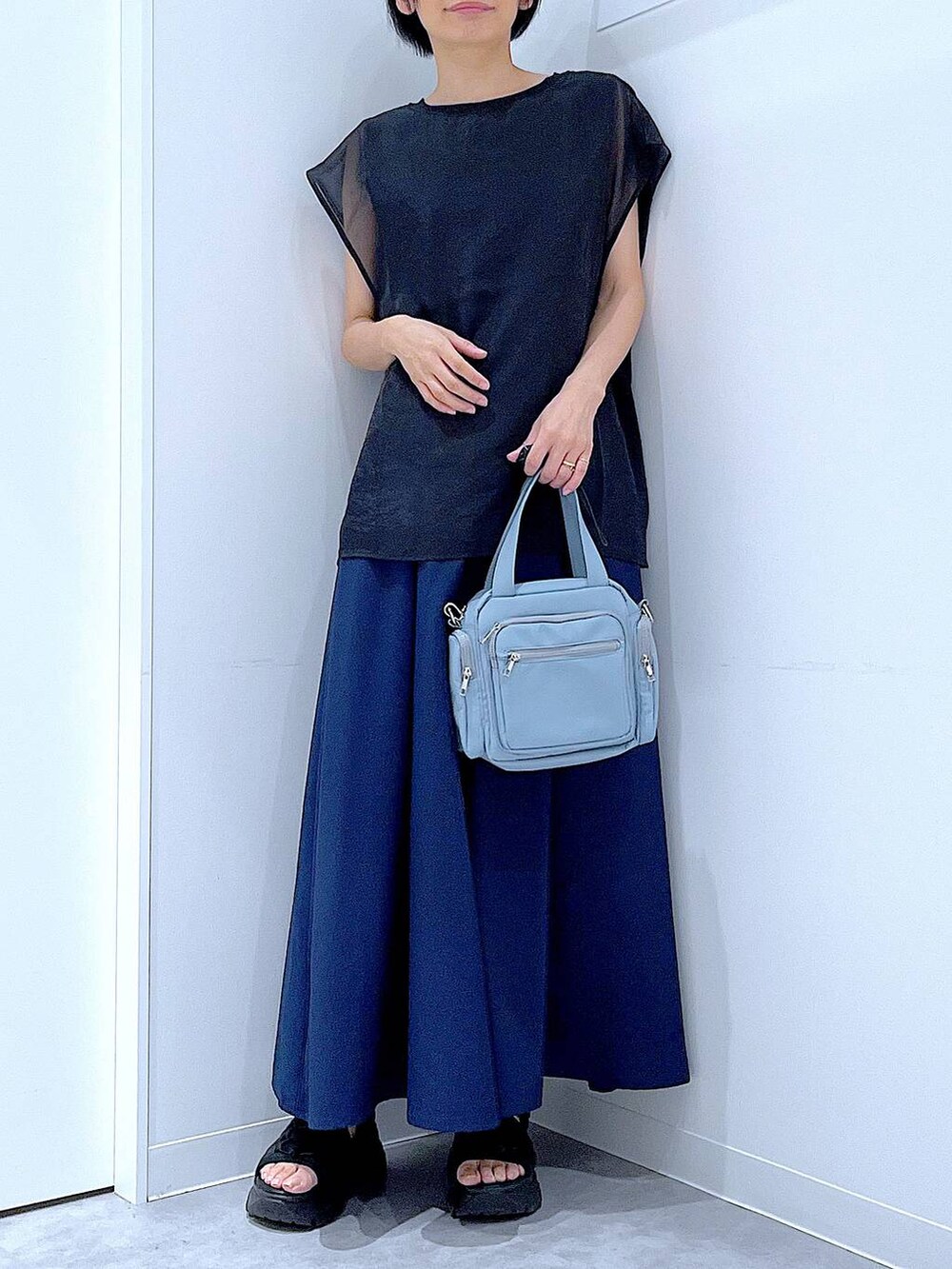 ブラック系のスニーカー、ブルー系のショルダーバッグ、ブルー系のその他パンツを着用したレディースの夏コーディネートの6枚目の写真