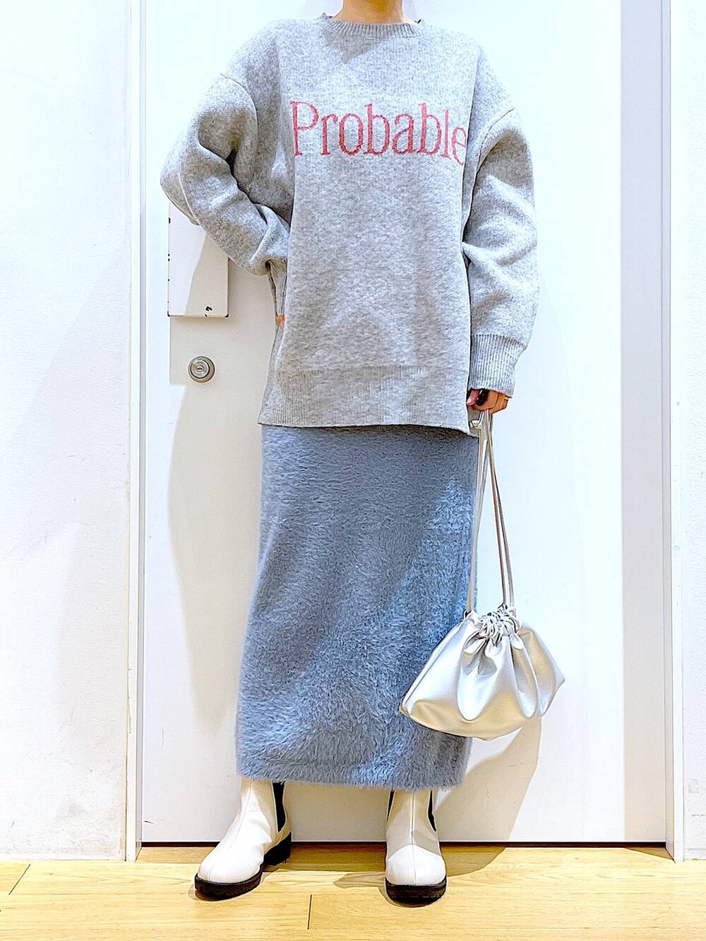 ベージュ系のブーツ、シルバー系のショルダーバッグ、ブルー系のスカートを着用したレディースの冬コーディネートの6枚目の写真