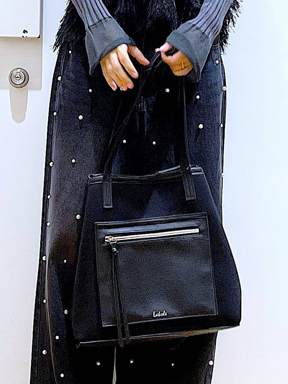 グレー系のニット/セーター、ブラック系のブーツ、ブラック系のトートバッグを着用したレディースの秋コーディネートの9枚目の写真