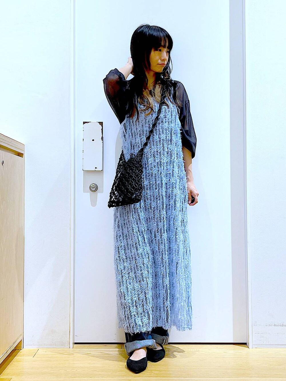 グレー系のニット/セーター、ブルー系のワンピース、ブラック系のパンプスを着用したレディースの春コーディネートの2枚目の写真