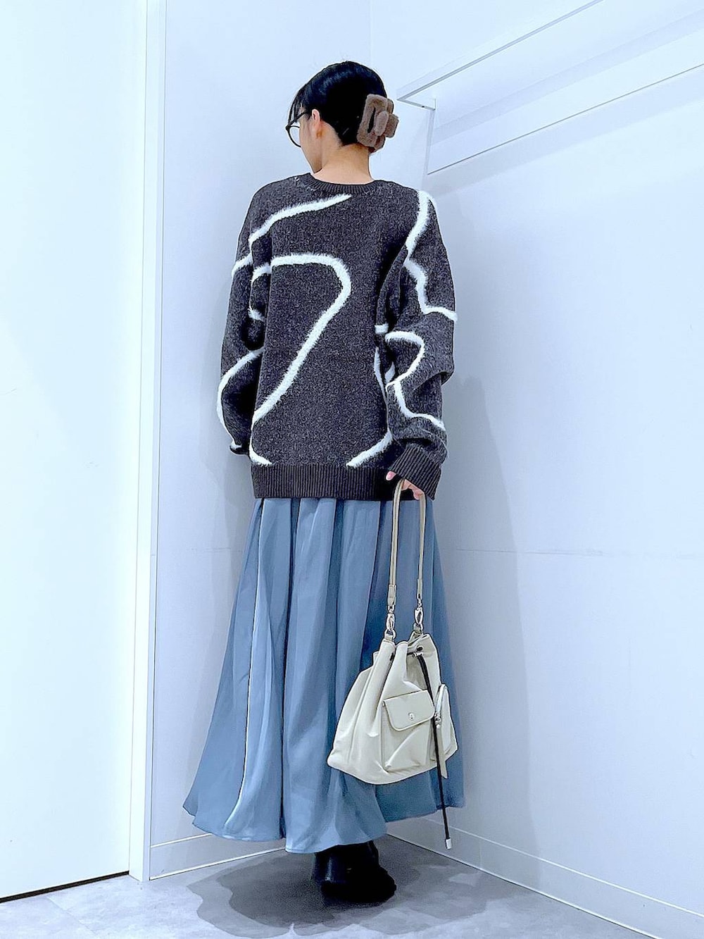 ブラック系のブーツ、グレー系のニット/セーター、ブラウン系のバレッタ/ヘアクリップを着用したレディースの冬コーディネートの5枚目の写真