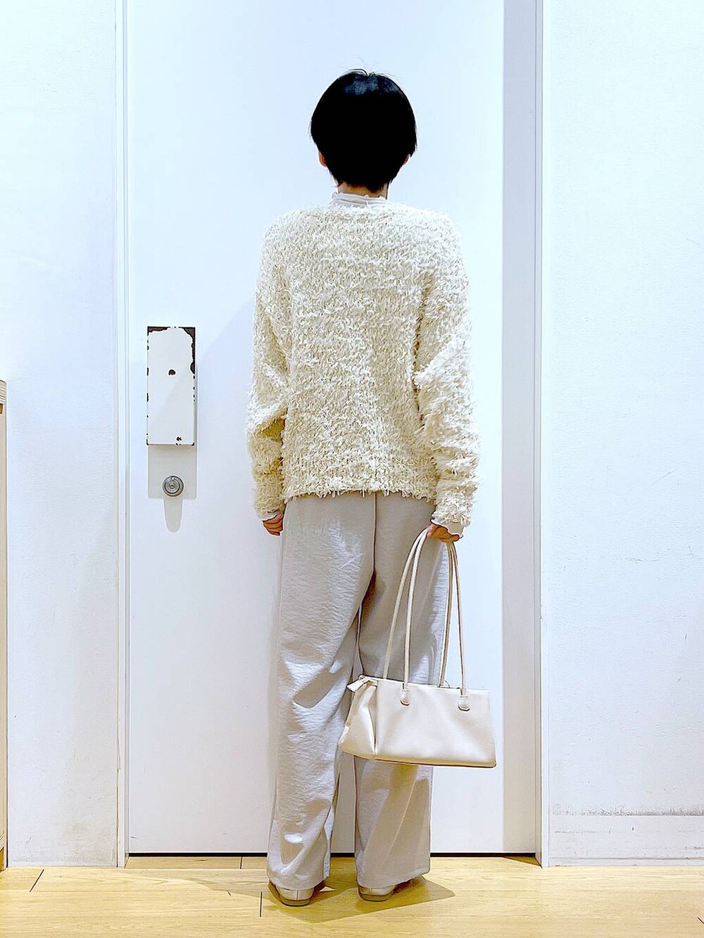 ホワイト系のトートバッグ、ベージュ系のTシャツ/カットソー、シルバー系のパンプスを着用したレディースの冬コーディネートの5枚目の写真