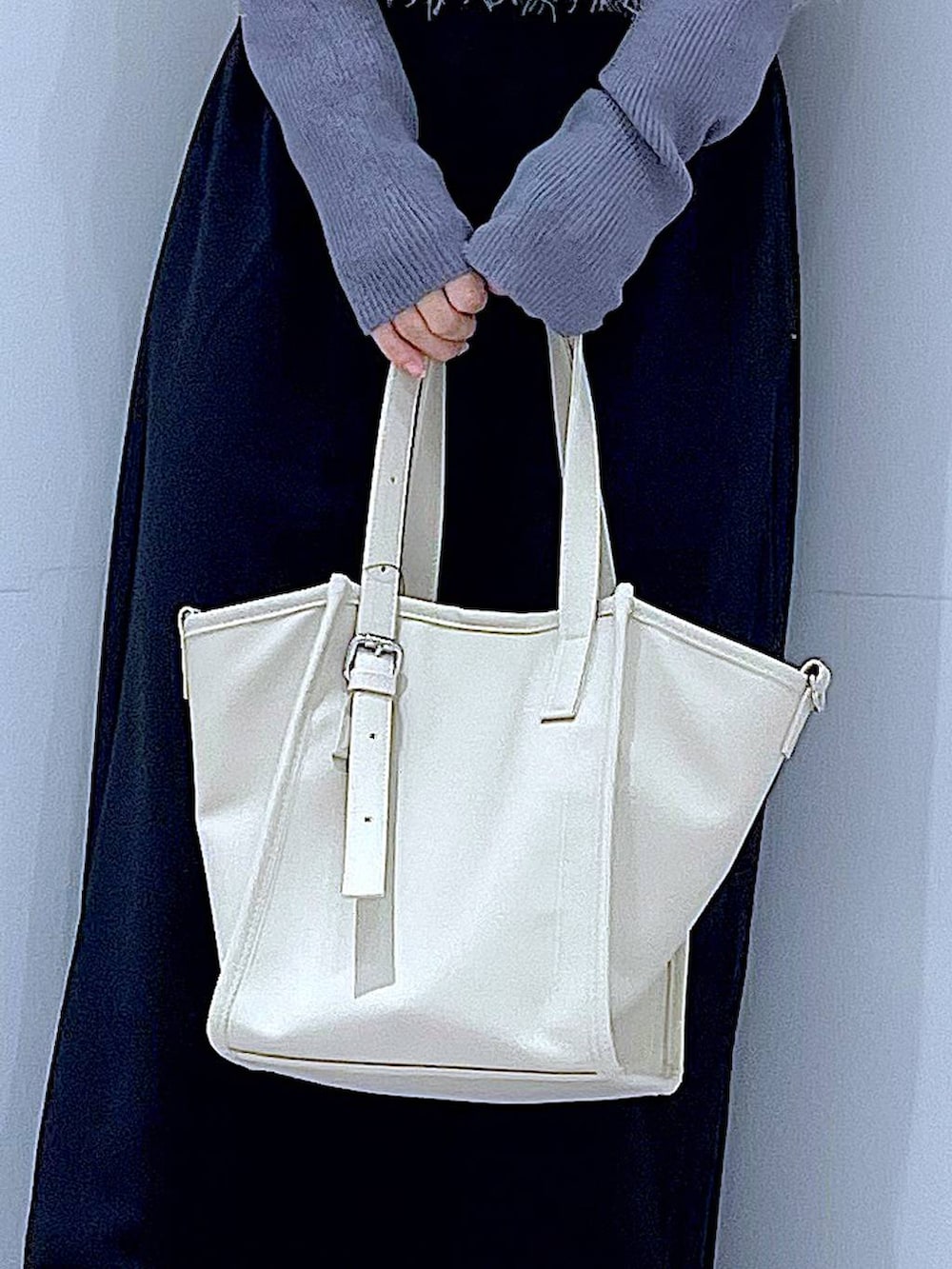 ブラック系のスカート、ブラック系のブーツ、グレー系のニット/セーターを着用したレディースの冬コーディネートの9枚目の写真