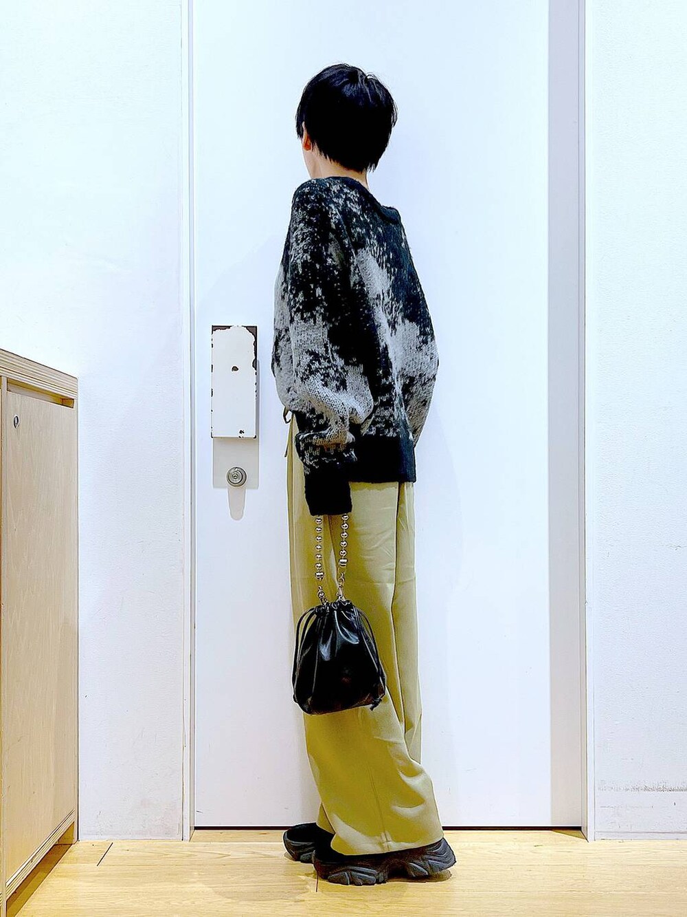 ブラック系のショルダーバッグ、ブラック系のブーツ、イエロー系のその他パンツを着用したレディースの冬コーディネートの3枚目の写真