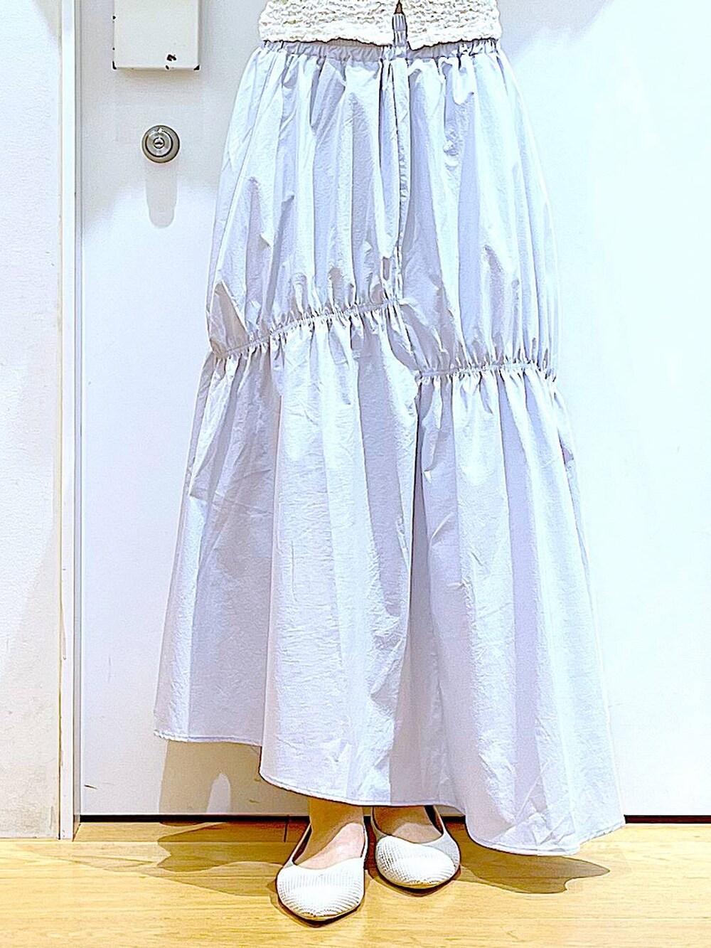 ホワイト系のカーディガン/ボレロ、イエロー系のニット/セーター、ホワイト系のパンプスを着用したレディースの春コーディネートの8枚目の写真