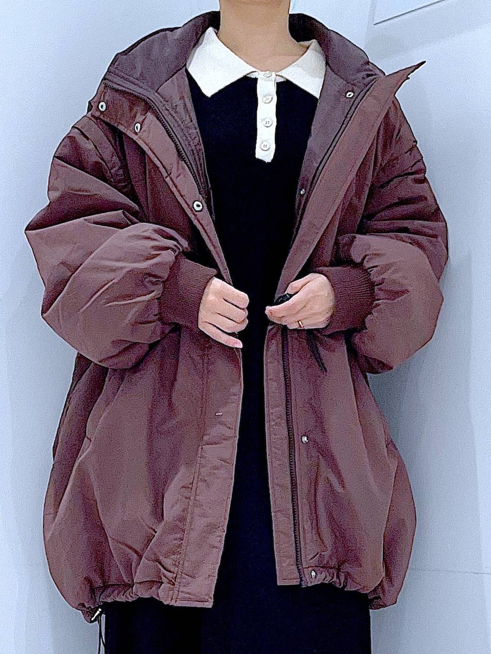 ブラウン系のブルゾン、ブラック系のブーツ、ブラック系のショルダーバッグを着用したレディースの冬コーディネートの7枚目の写真