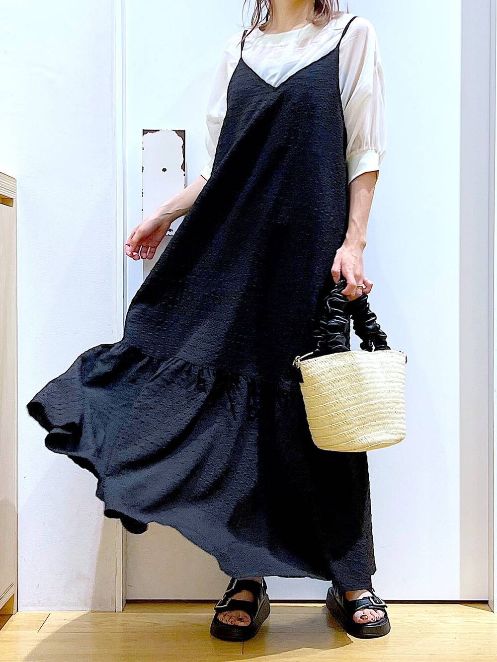 ブラック系のワンピース、ホワイト系のショルダーバッグ、ブラック系のサンダルを着用したレディースの夏コーディネートの6枚目の写真