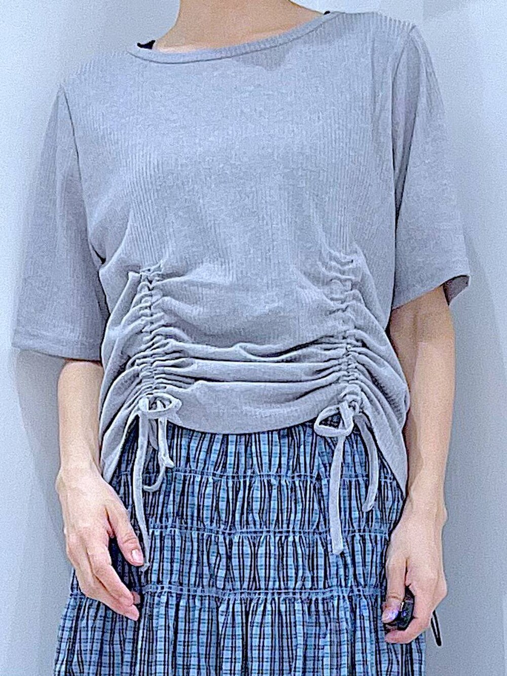 シルバー系のかごバッグ、シルバー系のサンダル、ブルー系のスカートを着用したレディースの夏コーディネートの7枚目の写真