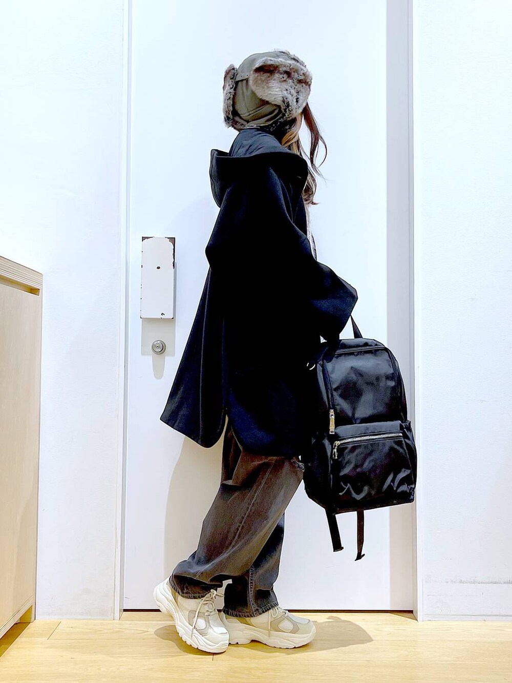 ブラック系のバックパック/リュック、ブラック系のその他アウター、ベージュ系のスニーカーを着用したレディースの冬コーディネートの4枚目の写真