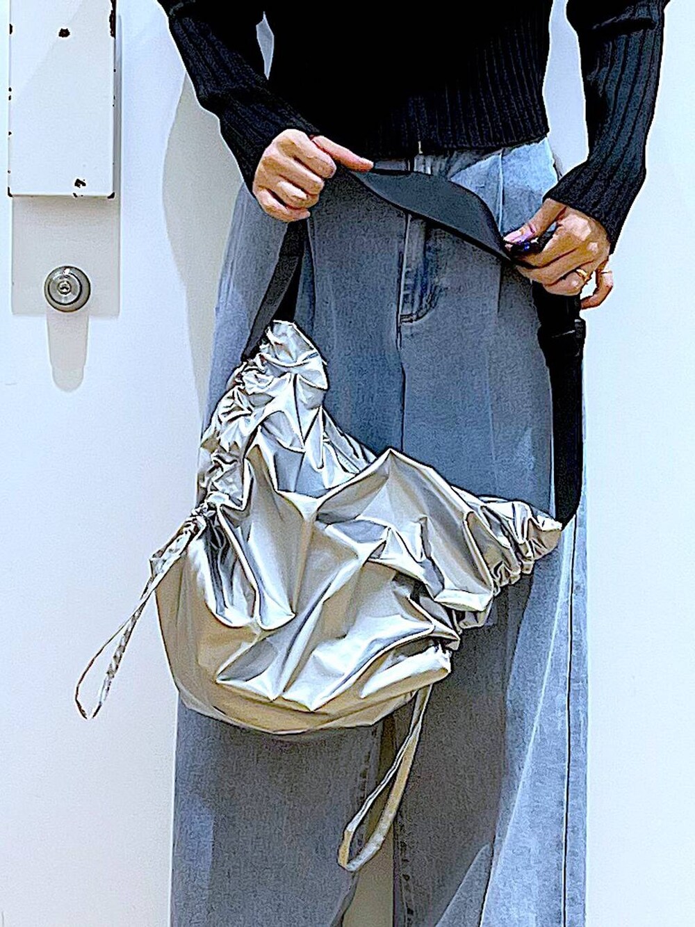 ブルー系のデニムパンツ、ブラック系のカーディガン/ボレロ、ベージュ系のブーツを着用したレディースの冬コーディネートの9枚目の写真