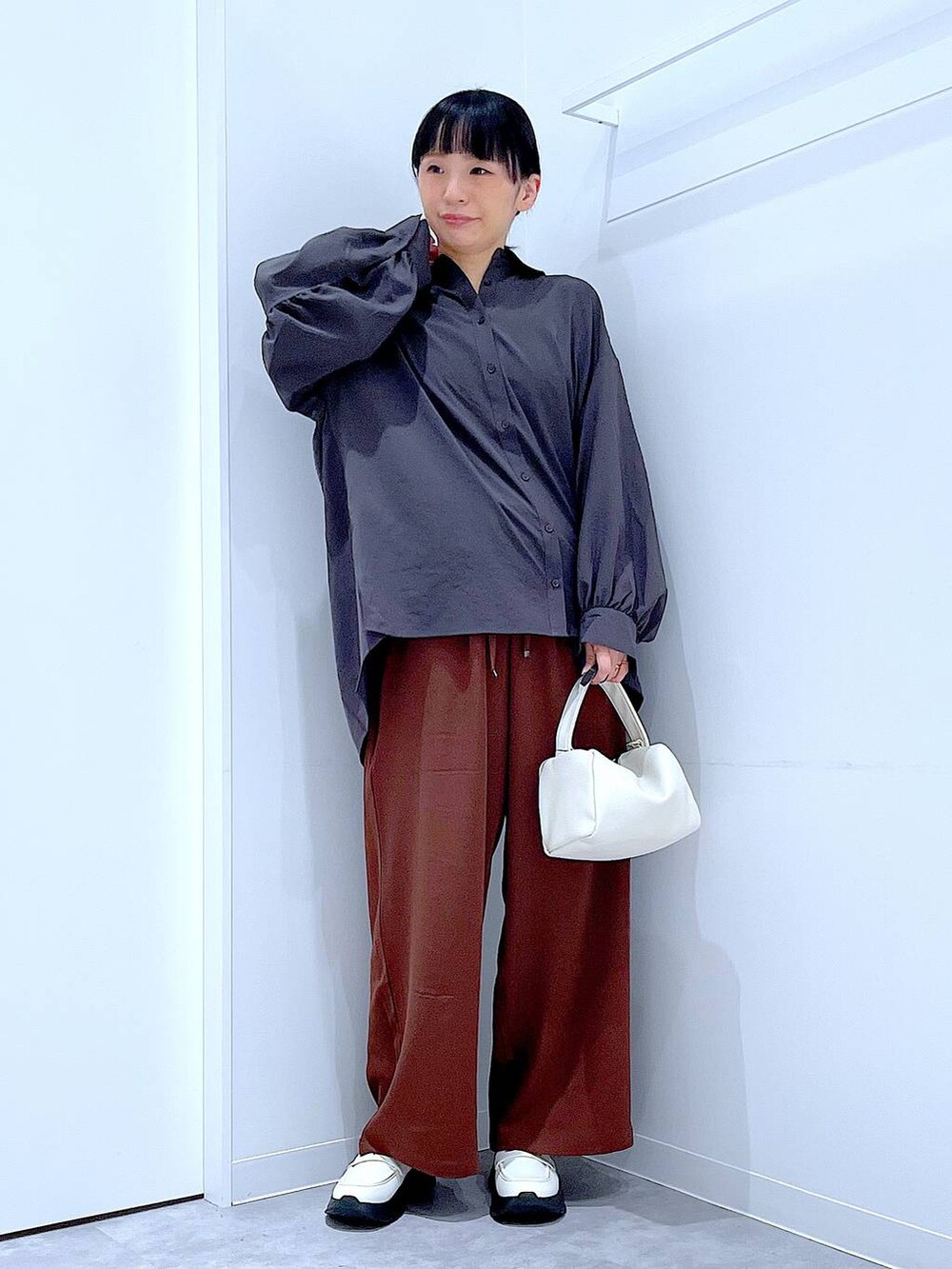 ホワイト系のローファー、ホワイト系のショルダーバッグ、ブラウン系のその他パンツを着用したレディースの秋コーディネートの2枚目の写真