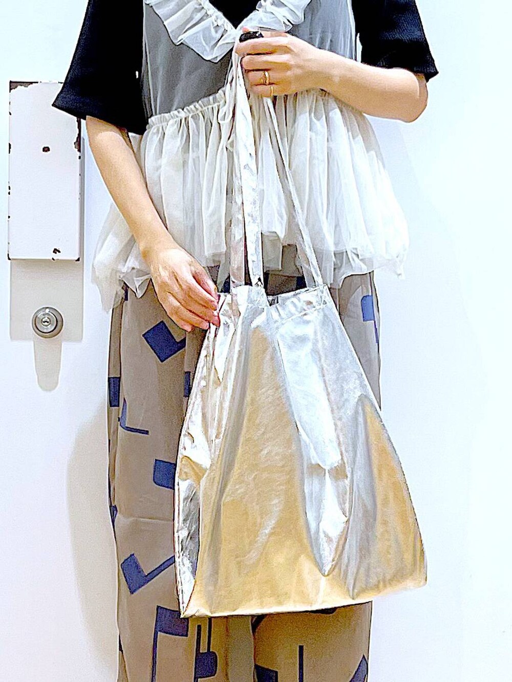 シルバー系のトートバッグ、グレー系のその他パンツ、ブラック系のサンダルを着用したレディースの夏コーディネートの9枚目の写真