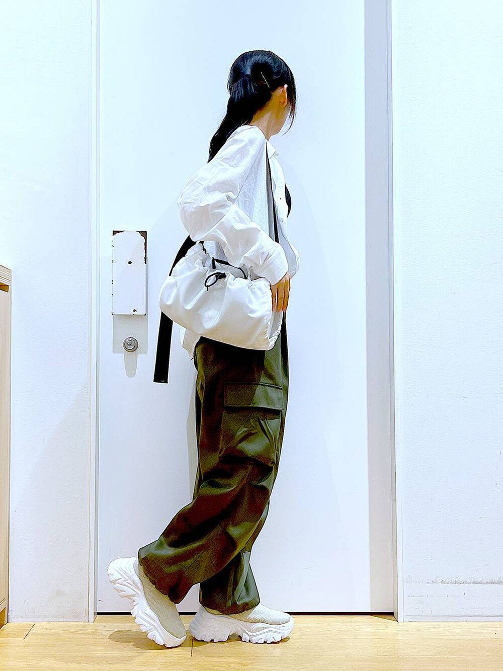 ホワイト系のシャツ/ブラウス、ホワイト系のショルダーバッグ、ベージュ系のスニーカーを着用したレディースの春コーディネートの4枚目の写真