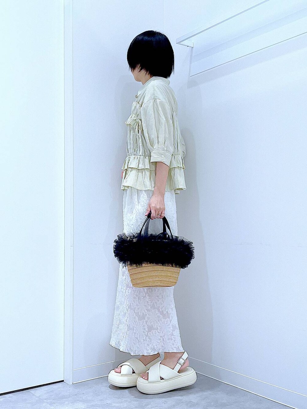 ベージュ系のショルダーバッグ、ホワイト系のサンダル、ホワイト系のスカートを着用したレディースの夏コーディネートの3枚目の写真