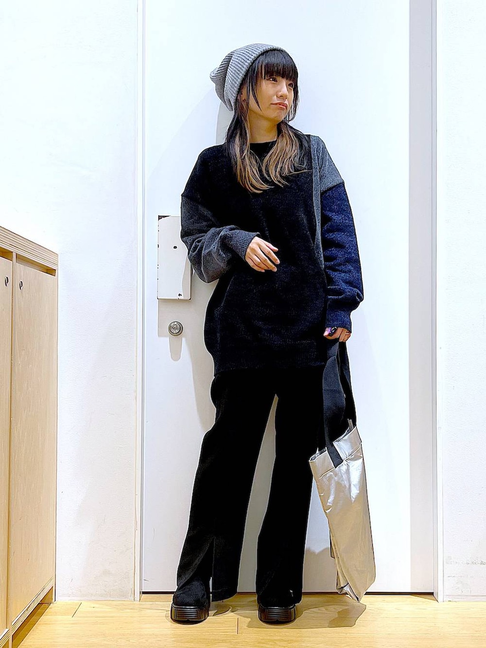 グレー系のニット/セーター、ブラック系のブーツ、ブラック系のその他パンツを着用したレディースの冬コーディネートの2枚目の写真