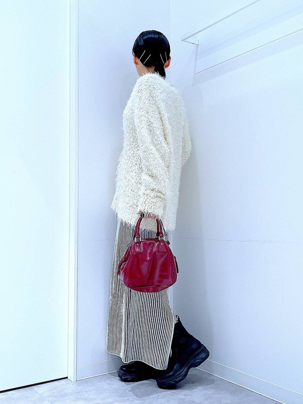 ブラック系のブーツ、ベージュ系のスカート、ベージュ系のカーディガン/ボレロを着用したレディースの秋コーディネートの3枚目の写真