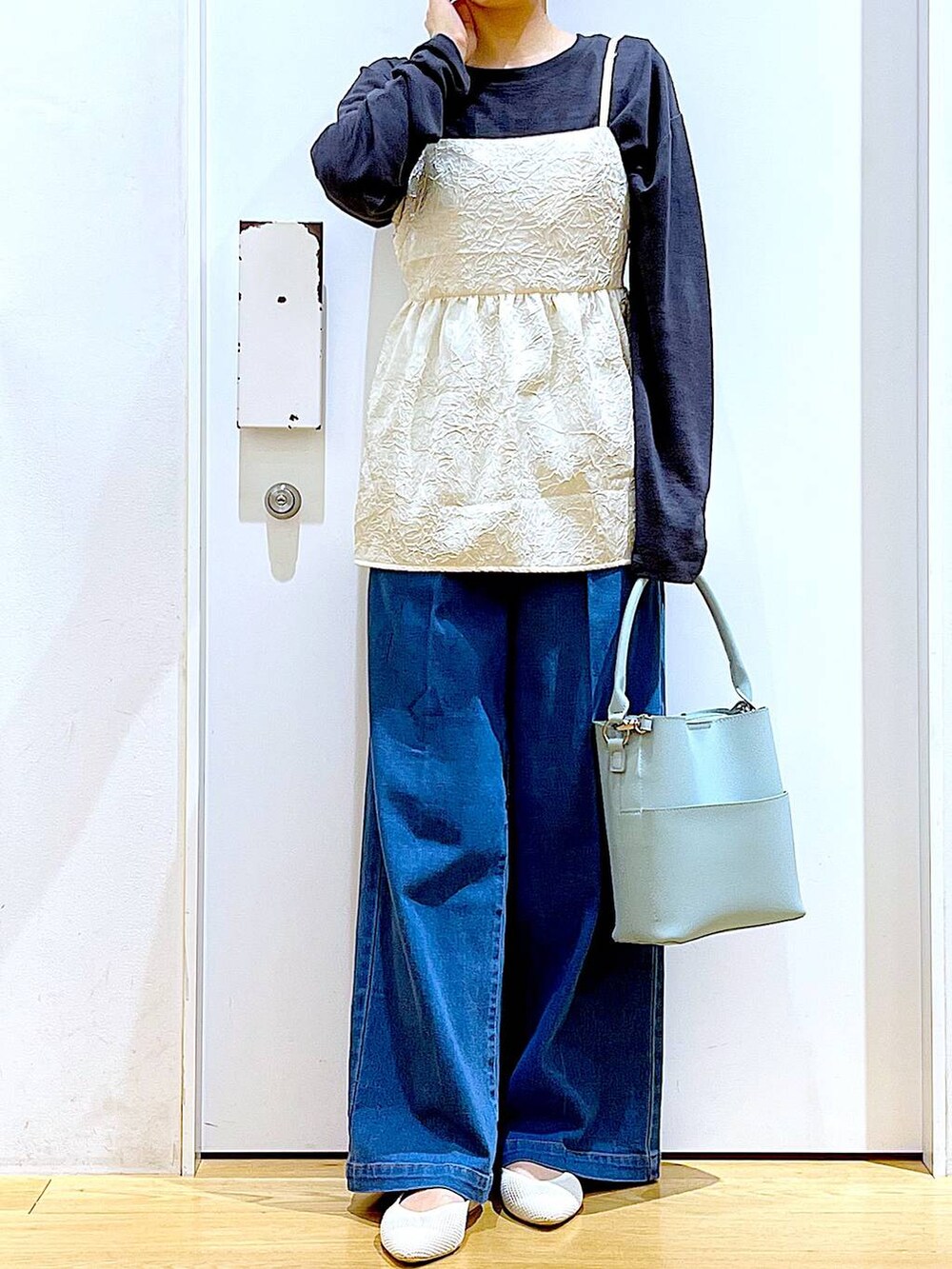 ブルー系のデニムパンツ、ホワイト系のキャミソール、グリーン系のショルダーバッグを着用したレディースの春コーディネートの6枚目の写真