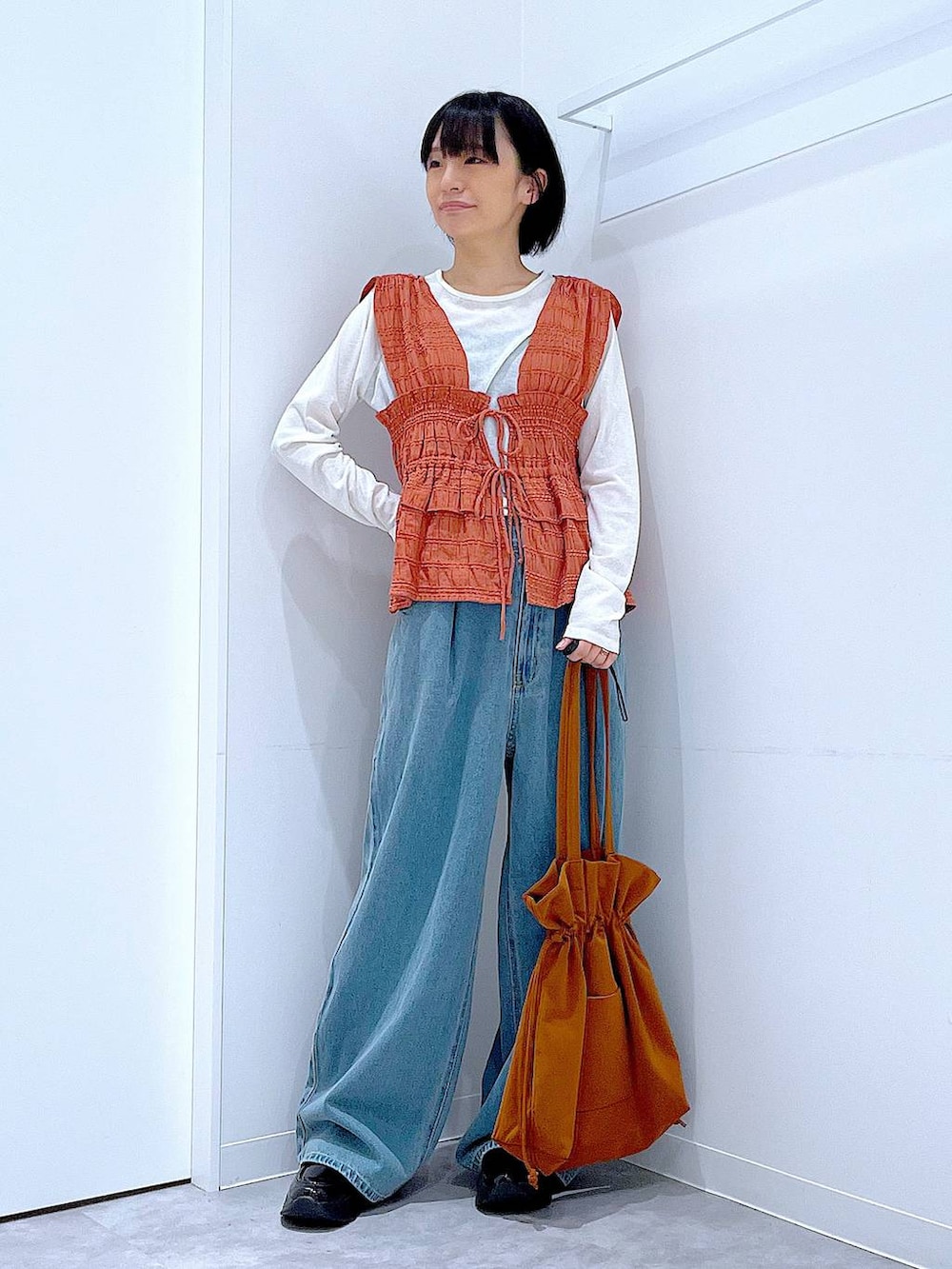 ホワイト系のTシャツ/カットソー、ブラック系のローファー、ブラウン系のトートバッグを着用したレディースの秋コーディネートの2枚目の写真