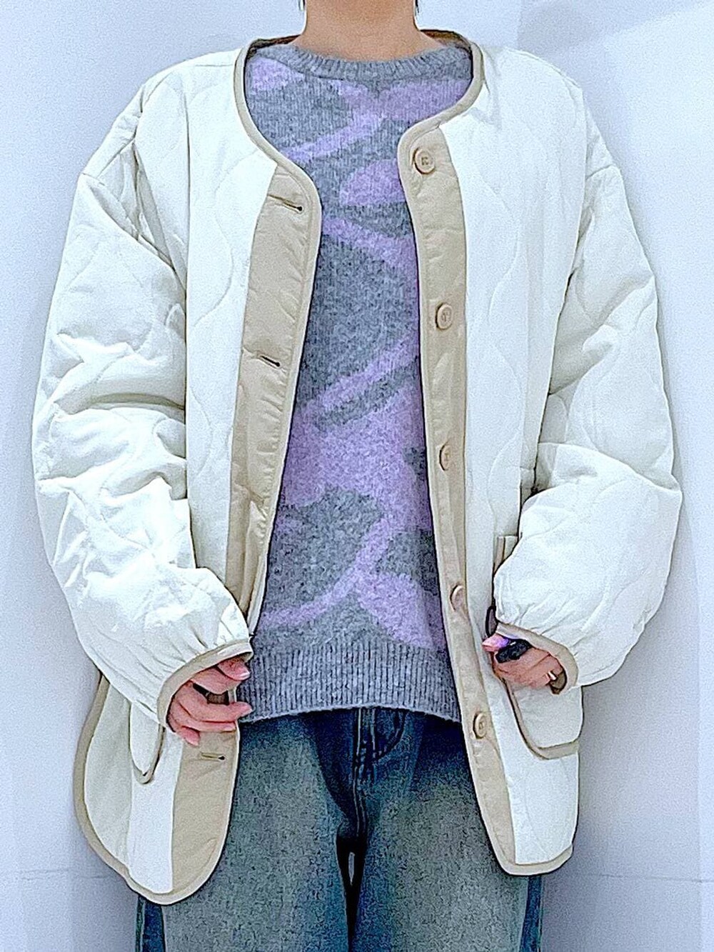ベージュ系のブルゾン、ブラック系のブーツ、ブルー系のデニムパンツを着用したレディースの冬コーディネートの7枚目の写真