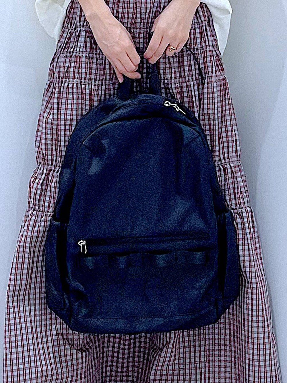 ブラック系のバックパック/リュック、シルバー系のサンダル、ホワイト系のTシャツ/カットソーを着用したレディースの夏コーディネートの9枚目の写真