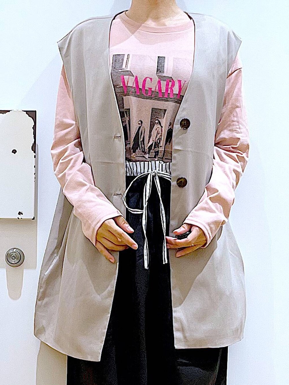 ベージュ系のショルダーバッグ、ブラック系のパンプス、ベージュ系のベストを着用したレディースの秋コーディネートの7枚目の写真