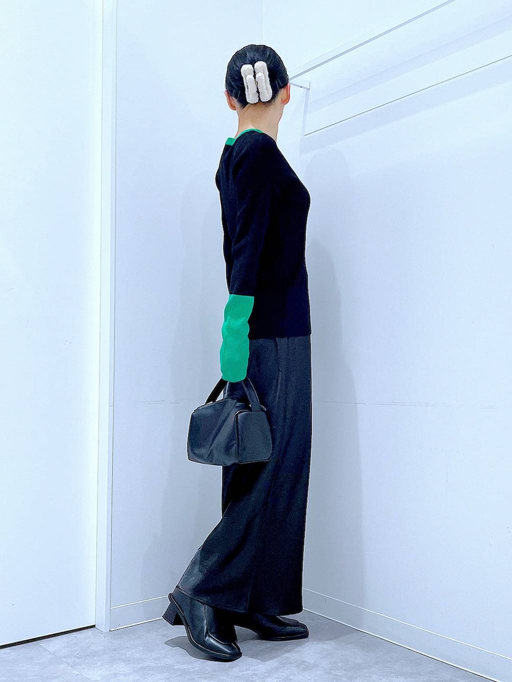 ブラック系のブーツ、ブラック系のショルダーバッグ、ブラック系のニット/セーターを着用したレディースの冬コーディネートの4枚目の写真