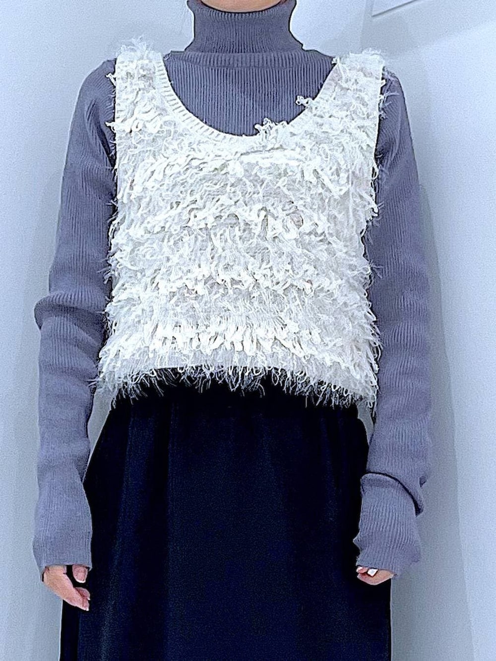 ブラック系のスカート、ブラック系のブーツ、グレー系のニット/セーターを着用したレディースの冬コーディネートの7枚目の写真