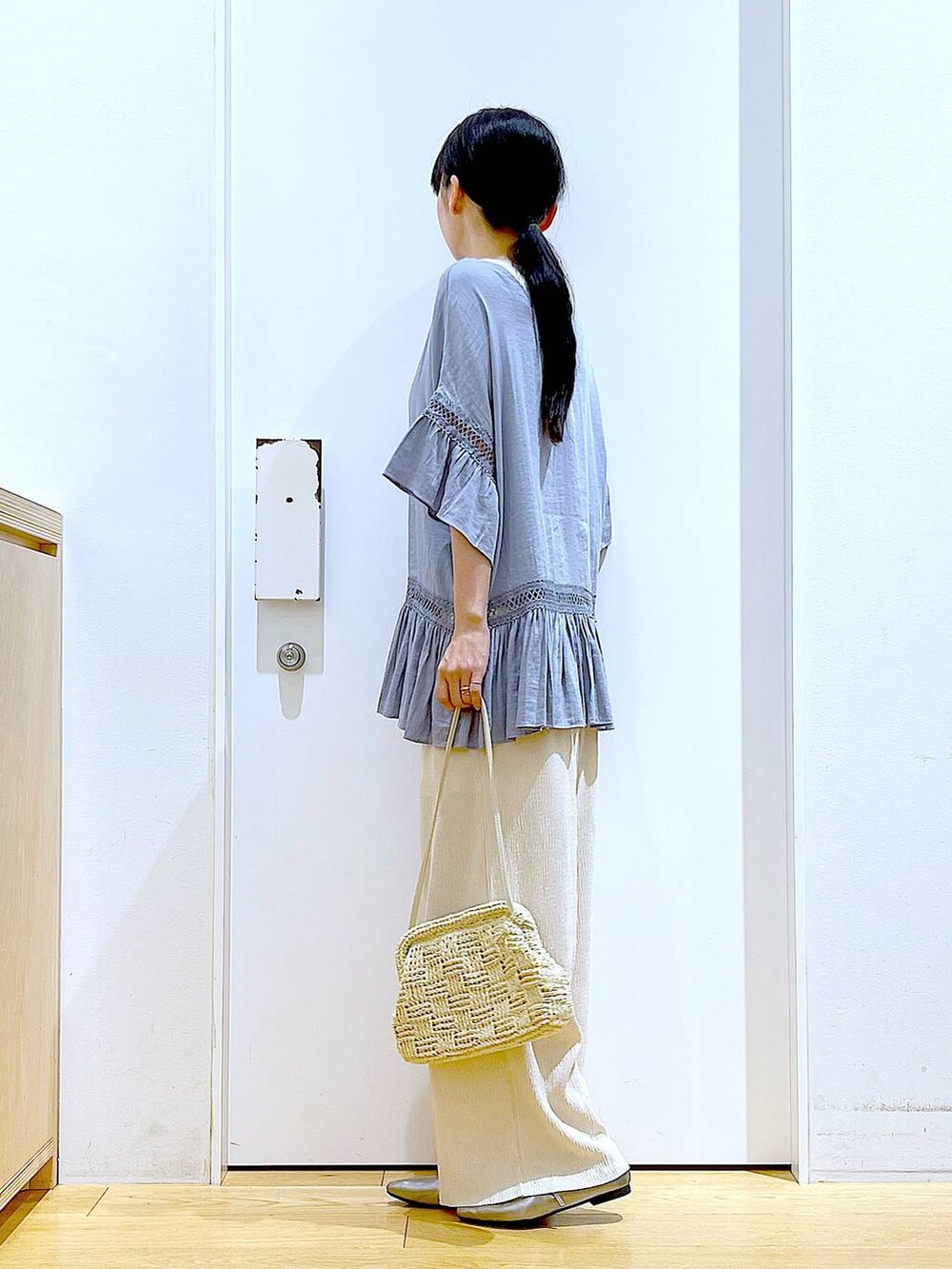 ブルー系のチュニック、その他のパンプス、ホワイト系のショルダーバッグを着用したレディースの春コーディネートの3枚目の写真