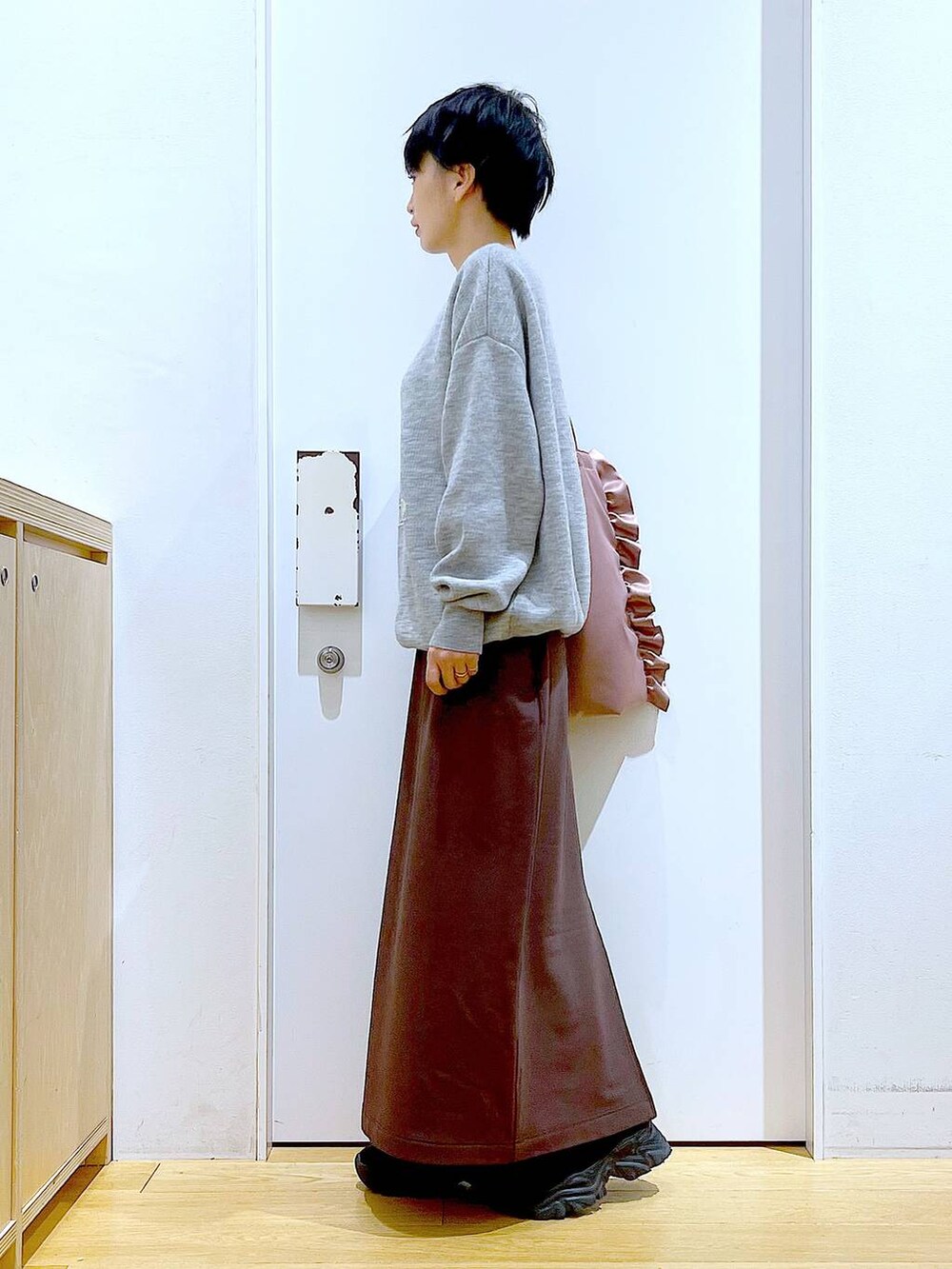 ブラック系のブーツ、ピンク系のトートバッグ、ブラウン系のスカートを着用したレディースの冬コーディネートの3枚目の写真