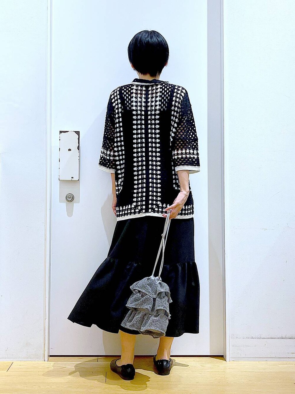 シルバー系のショルダーバッグ、ブラック系のパンプス、ブラック系のワンピースを着用したレディースの春コーディネートの5枚目の写真