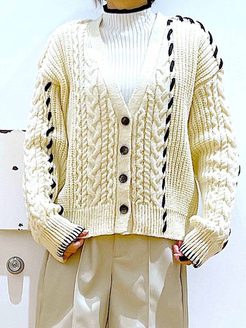 ベージュ系のニット/セーター、ブルー系のショルダーバッグ、ベージュ系のブーツを着用したレディースの冬コーディネートの7枚目の写真