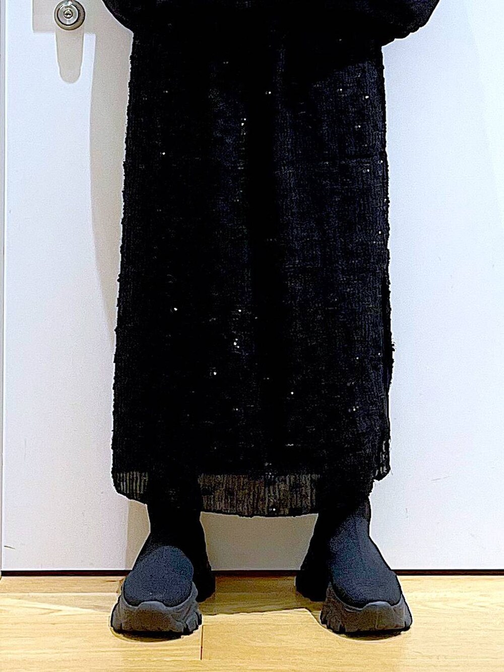 グリーン系のニット/セーター、ブラック系のハンドバッグ、ブラック系のブーツを着用したレディースの秋コーディネートの8枚目の写真