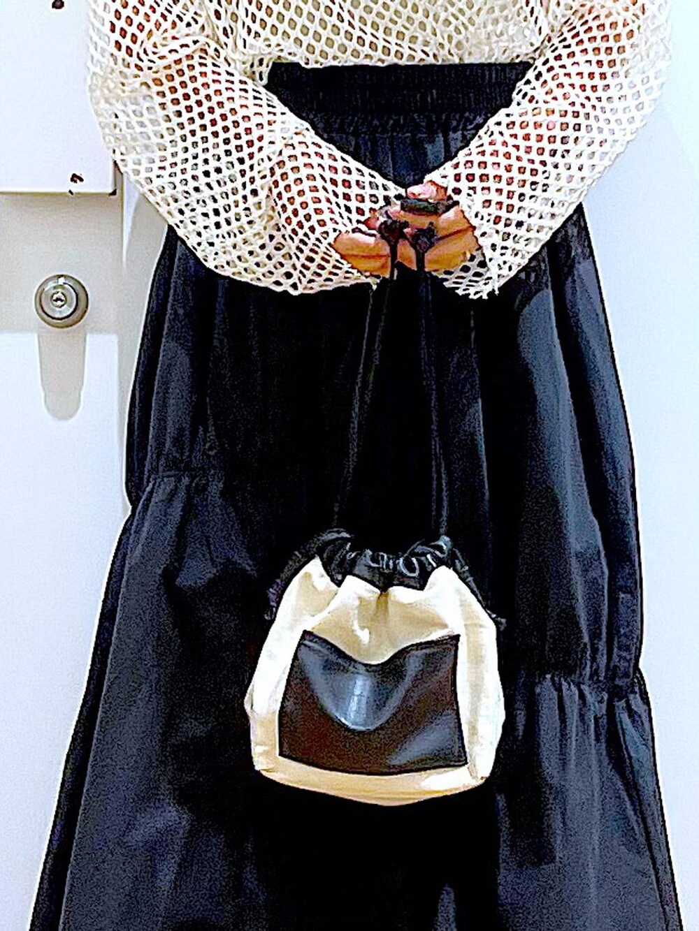 ホワイト系のTシャツ/カットソー、ホワイト系のショルダーバッグ、イエロー系のニット/セーターを着用したレディースの春コーディネートの9枚目の写真