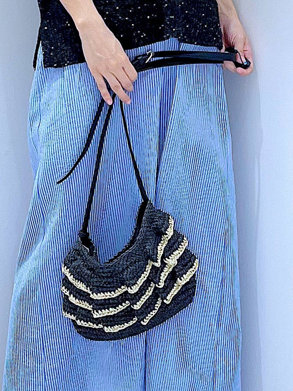 ブラック系のショルダーバッグ、シルバー系のサンダル、ブラック系のベストを着用したレディースの夏コーディネートの9枚目の写真