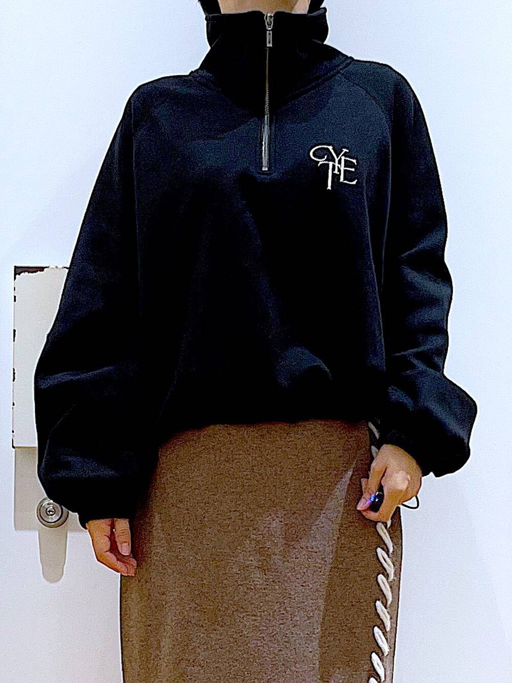 ブラック系のブーツ、ブラウン系のスカート、ブラック系のスウェットを着用したレディースの冬コーディネートの7枚目の写真