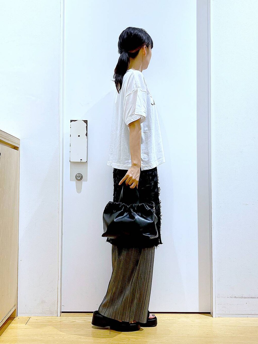 ブラック系のサンダル、ブラック系のショルダーバッグ、ブラック系のスカートを着用したレディースの秋コーディネートの4枚目の写真