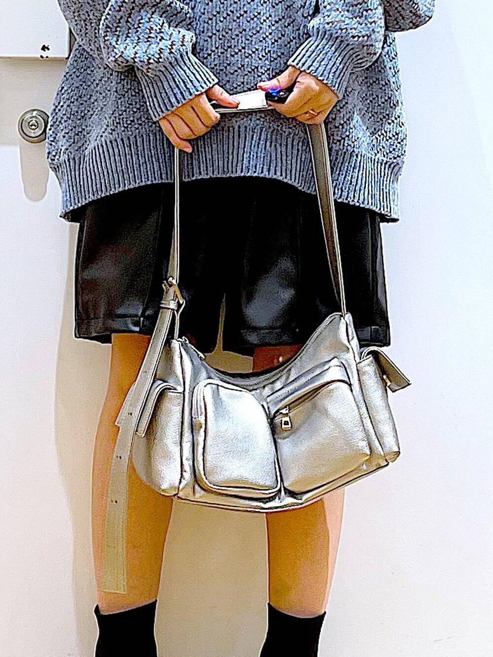 ブルー系のニット/セーター、ブラック系のブーツ、その他のショルダーバッグを着用したレディースの冬コーディネートの9枚目の写真