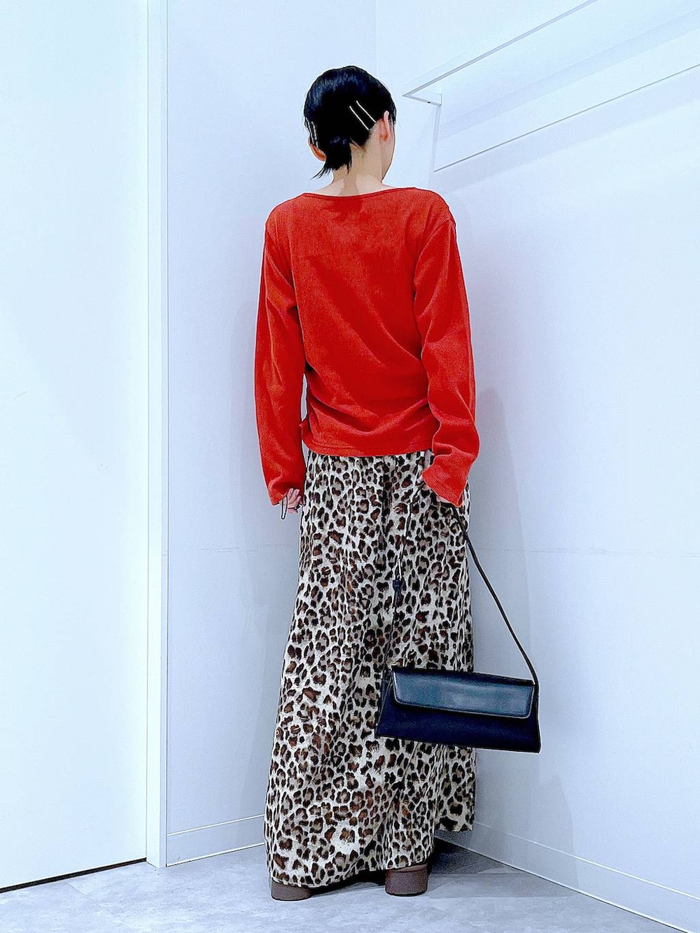 ブラック系のショルダーバッグ、ブラウン系のブーツ、ブラウン系のスカートを着用したレディースの秋コーディネートの5枚目の写真