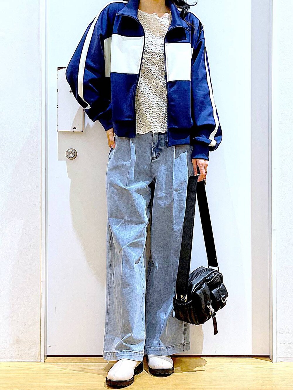 ブルー系のデニムパンツ、ベージュ系のブーツ、ブラック系のショルダーバッグを着用したレディースの冬コーディネートの6枚目の写真